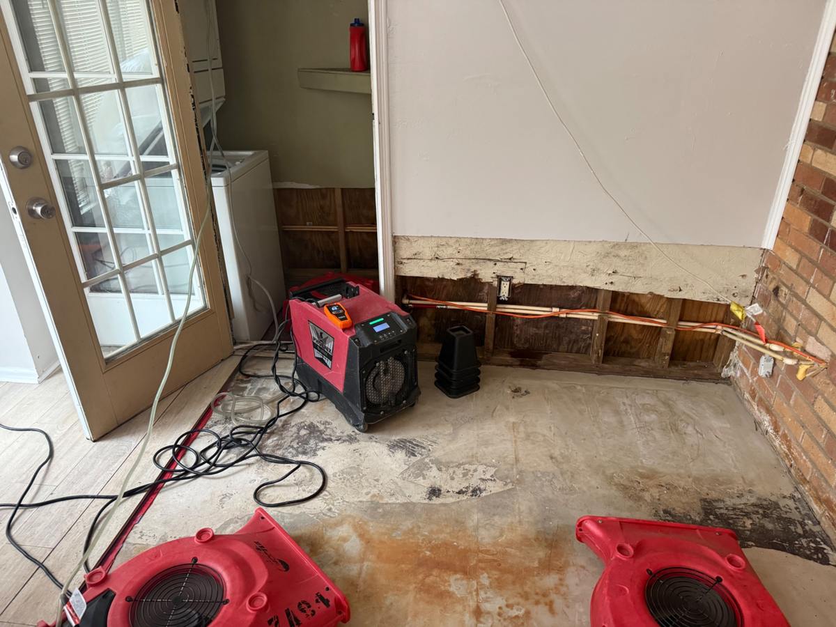 Water-damaged wall removed with dehumidifier running